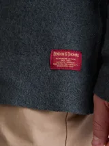 Overshirt de tejido de punto color azul marino, con cuello camisero, cierre frontal de botones y dos bolsillos frontales tipo parche.