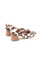 Zapato cerrado de cuero con estampado tipo animal print de vaca en tonos marrón y blanco, con punta fina y taco medio ancho.