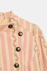 Cazadora de jacquard con estampado de rayas y detalles florales en tonos rosados y beige, cuello redondo, manga larga, bolsillos delanteros de vivo y cierre frontal cruzado con botones metálicos.