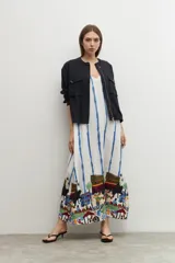 Maxi vestido blanco con rayas verticales azules y estampado de paisaje en el ruedo.