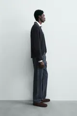 Polo de punto color azul marino, de calce relajado y manga larga. Presenta un cuello solapa de tejido denim en contraste con una abertura frontal en forma de V.