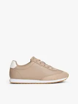 Zapatillas de corte bajo Tommy Hilfiger confeccionadas en piel napa color beige. Presentan paneles con mezcla de texturas, cordones tonales, suela de EVA blanca y detalle de contraste en el talón. Incluyen logo metálico de la marca en el lateral.