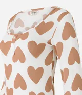Conjunto de pijama canelado blanco con estampado de corazones marrones. Incluye blusa de mangas largas y pantalón con cintura elástica y puños ajustados.