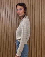 Cardigan de punto a rayas horizontales en tonos beige y tostado, con cuello camisero, cierre frontal de botones y mangas largas.