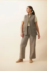 Chaleco color crema con solapas, corte entallado y bolsillos plaqué.