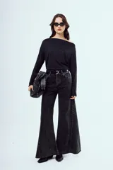 Top negro de manga larga, con escote asimétrico estilo off-shoulder y diseño drapeado.