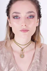 Gargantilla con doble tira de cuero color verde oliva y dije de sol en bronce con detalle de zirconia.