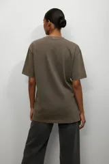 Remera de algodón color negro con efecto lavado, de corte holgado y manga corta. Presenta un estampado frontal con texto y una estrella en tonos claros.