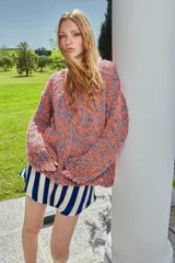 Sweater tejido a mano de lana multicolor, con calce holgado, cuello redondo y puños ajustados.