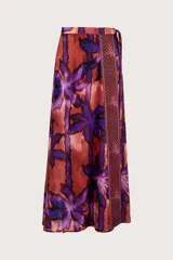 Falda tipo pareo de diseño envolvente con estampado de hojas en tonos púrpuras y cobrizos, con una franja lateral de patrón geométrico.