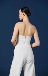 Pantalón de mujer color blanco, de corte amplio y silueta fluida, con cintura definida y puños ajustables con tiras para atar en los tobillos.