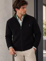 Campera negra de tejido fino, con cierre frontal y cuello alto con interior verde.
