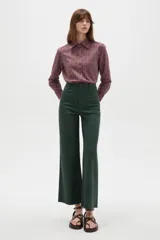 Pantalon tipo jean de corte flare y tiro alto, color verde oscuro, con cierre frontal y bolsillos.