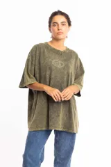 Remera oversize de manga corta, color verde musgo con efecto gastado (acid wash) y un pequeño logo circular bordado en el centro del pecho.