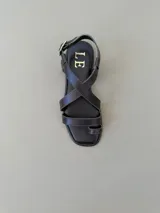 Sandalias de cuero color marrón con diseño de tiras cruzadas en el empeine, sujetador para el dedo y tira ajustable con hebilla en el talón.