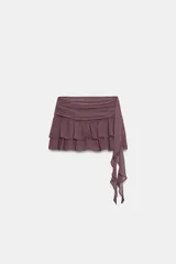 Falda pantalón de tiro medio en color bordó con estampado de lunares pequeños. Presenta un diseño con volantes escalonados y un detalle asimétrico lateral con caída fluida.