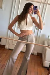 Pantalón Oxford de cuero ovino color visón con pasamanería a tono en los tajos laterales. Cierre frontal con cremallera.