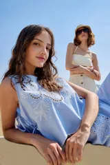 Musculosa de algodón color celeste, con cuello redondo y detalles bordados en tono blanco con diseño de broderie en la parte frontal. Cuenta con cordones laterales para ajustar.