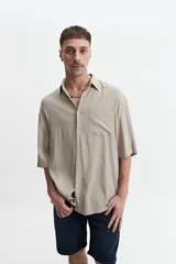 Camisa blanca de manga corta, corte oversize y cuello clásico.