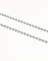 Collar de cadena formado por esferas continuas, con cierre de mosquetón y cadena de extensión. Está fabricado en una aleación de metales con baño de oro de 18k.