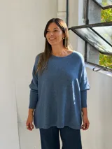 Sweater de punto color azul, con cuello redondo, corte holgado y mangas largas con puños ajustados.