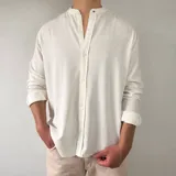 Camisa de lino manga larga de color blanco, con cuello mao y cierre frontal con botones.
