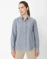 Camisa celeste de manga larga con cuello clásico, cierre con botones y dos bolsillos en el pecho.