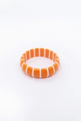 Pulsera rígida naranja con rayas verticales blancas.