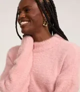 Suéter de punto color crema con cuello redondo y mangas largas ajustadas. Modelo slim alargado con efecto de pelitos.