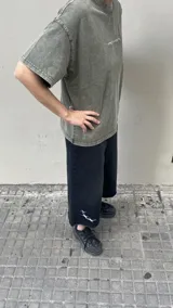 Bermuda de jean negra, corte ancho, largo a la rodilla y detalle de estrellas blancas en la pierna izquierda.