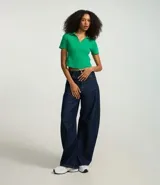 Blusa de cuello polo y manga corta, confeccionada en tejido rib de algodón con elastano. Presenta un diseño ajustado al cuerpo con escote en V y textura acanalada.