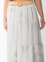 Falda larga de estilo campesino color crudo, confeccionada en algodón italiano con apliques florales al tono. Tiene cintura elastizada y cinto de rafia elastizado desmontable.