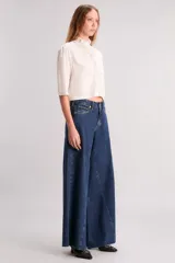 Pantalón de jean azul oscuro, de corte wide leg y tiro alto.