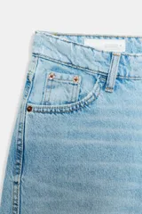 Jeans de tiro medio con diseño cropped, confeccionados en denim gris con efecto lavado. Presentan costuras laterales torcidas, trabillas para cinturón, cinco bolsillos y cierre frontal con cremallera y botón metálico.