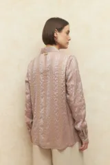 Camisa blanca de manga larga con estampa a rayas y apliques de volados frontales.