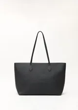 Cartera tipo tote de diseño minimalista y estructura flexible, color negro, con asas largas para llevar al hombro.