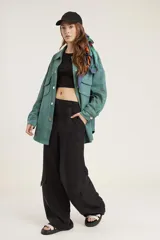 Pantalón de corte amplio y tiro alto, confeccionado en tela cupro, con bolsillos laterales tipo cargo y diseño holgado.