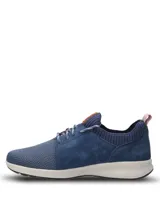 Championes casuales Hush Puppies modelo Spinal Knit, color azul marino. Presentan una combinación de tejido técnico transpirable en la puntera y laterales de cuero gamuzado. Incluyen cordones jaspeados, cuello tejido elástico y suela ergonómica de color blanco con tecnología Spinal para soporte postural.