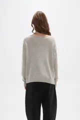 Sweater de tejido de punto color beige con estampado jacquard de leopardo en color negro. Presenta cuello redondo amplio y puños y ruedo acanalados.