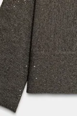 Jersey de punto color marrón oscuro con lentejuelas plateadas, cuello barco y manga larga acampanada.