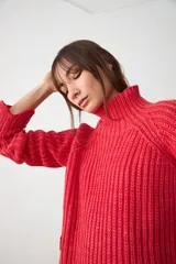 Sweater de punto acanalado en color rojo, con cuello alto y diseño de corte cropped con mangas largas.