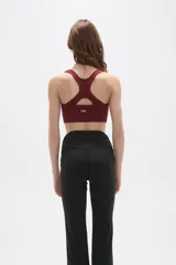 Top deportivo de color bordó con cuello en V, breteles regulables y diseño ajustado al cuerpo.