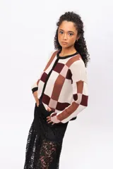 Saco tipo cardigan de punto con diseño geométrico de bloques en tonos beige, marrón y bordó. Presenta cuello redondo, cierre frontal con botones negros y mangas largas con puños en contraste.