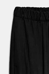 Pantalón de tiro medio con cintura elástica y pierna ancha. Presenta bolsillos laterales ocultos en la costura y un diseño fluido.