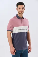 Remera polo de manga corta con diseño en bloques de color en tonos azul marino, blanco y verde militar, con bordado frontal y cierre de botones.