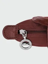 Cartera pouch Le Pliage de Longchamp, modelo compacto en color bordó con asa superior corta y cierre de solapa con botón a presión.