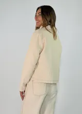 Chaqueta de pana color marrón, con solapas desflecadas, cierre frontal con botones y bolsillos delanteros con solapa desflecada.