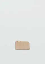 Porta documentos tipo tarjetero de efecto piel en color beige, con cierre de cremallera superior, llavero incorporado y ranuras para tarjetas.