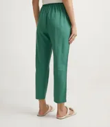 Pantalón de corte fluido y cintura media con cordón ajustable. Presenta diseño liso con bolsillos laterales y confección en tejido de viscolino.