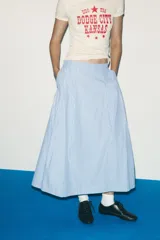 Falda midi celeste con rayas verticales finas en azul marino, de tiro alto, con pliegues en el delantero y cierre lateral con cremallera oculta.